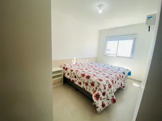 Quarto com cama e janela em ambiente claro.