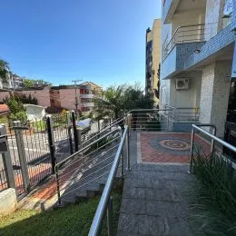 Vista externa de um terraço com grade metálica e vegetação em um imóvel em Lajeado.