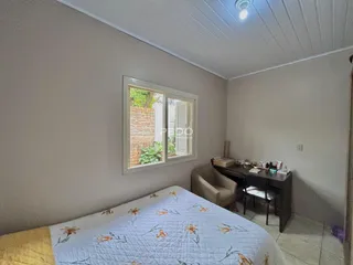 Quarto com cama e janela em uma residência.