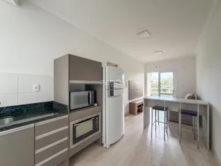 Interior de uma sala de estar com cozinha moderna em um apartamento.