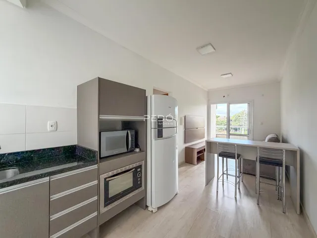 Interior de uma sala de estar com cozinha moderna em um apartamento.