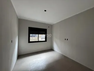 Ambiente interno de uma sala com paredes brancas e piso claro.