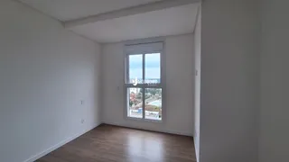 Ambiente interno de uma sala com piso de madeira e janela.