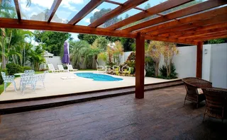 Vista de um jardim com piscina e deck de madeira em Lajeado.