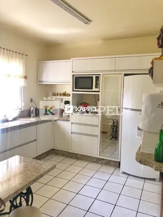 Foto de uma cozinha com armários brancos e piso de cerâmica.