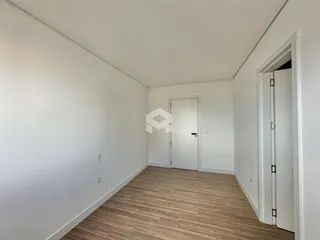 Um ambiente interno com paredes brancas e piso de madeira clara.
