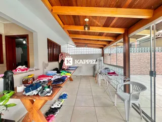 Ambiente interno com forro de madeira e portas de vidro que dão acesso ao exterior.