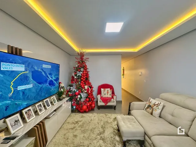 Sala de estar moderna com decoração de Natal e televisão.