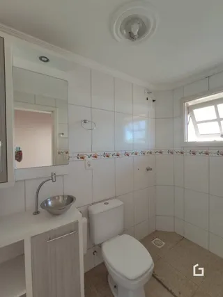 Foto de um banheiro interno com azulejos brancos.