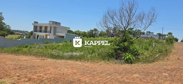 Fachada de uma casa moderna em Lajeado, Brasil, com vegetação no primeiro plano.