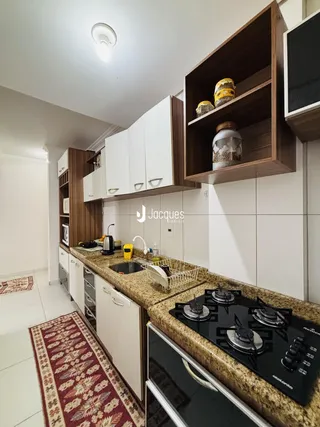 Foto de uma cozinha moderna com armários brancos e bancada de granito.