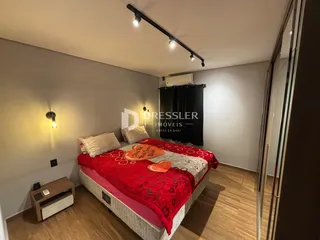 Quarto com cama e piso de madeira na residência.
