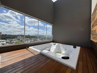 Vista de uma área com banheira e grande janela de vidro em uma propriedade.