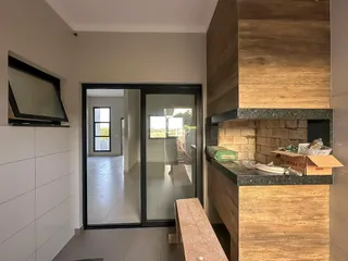 A sala de estar mostra uma parede branca e uma porta de vidro que leva a outra área.