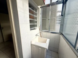 Foto de um banheiro com revestimento de azulejos brancos.