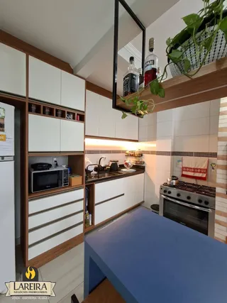 Foto de uma cozinha com armários brancos e madeira em Lajeado.