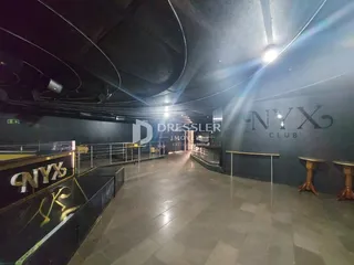Um corredor interno com piso de cerâmica e sinalização de clube.