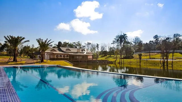 Vista da piscina ao ar livre com paisagem verde ao redor.