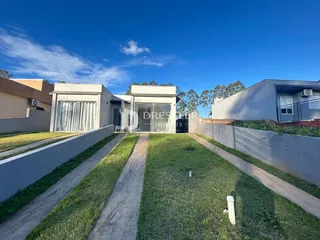 Vista da fachada de uma residência em Lajeado, Brasil, com jardim e muro frontal.