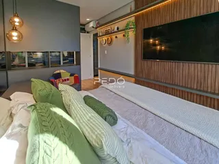 Quarto com cama e almofadas decorativas em um imóvel no Brasil.