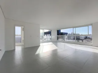 Ambiente interno de uma sala com grandes janelas que oferece uma vista da paisagem.