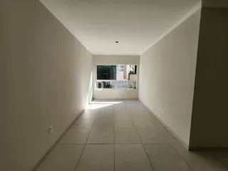 Corredor interno de uma residência com piso de cerâmica clara.