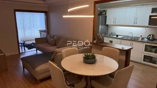 Sala de estar com mesa de jantar e vista para o exterior.