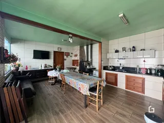 Ambiente interno de uma sala de jantar e cozinha com piso de madeira