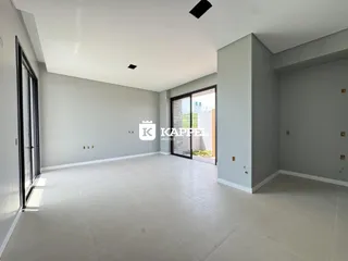 Foto de um ambiente interno amplo com piso claro e portas de vidro.