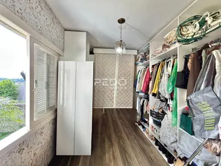Hall de entrada com janela e armário no interior de uma residência.