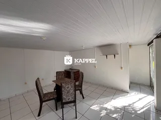 Uma sala de jantar com mesa e cadeiras em um imóvel.