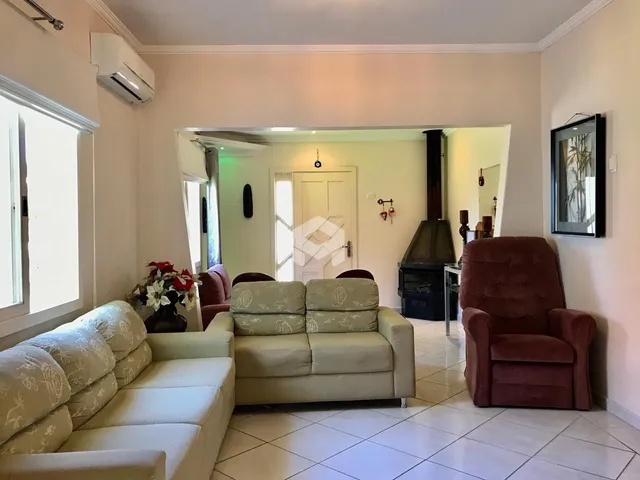 Sala de estar com sofá e poltronas em ambiente claro.