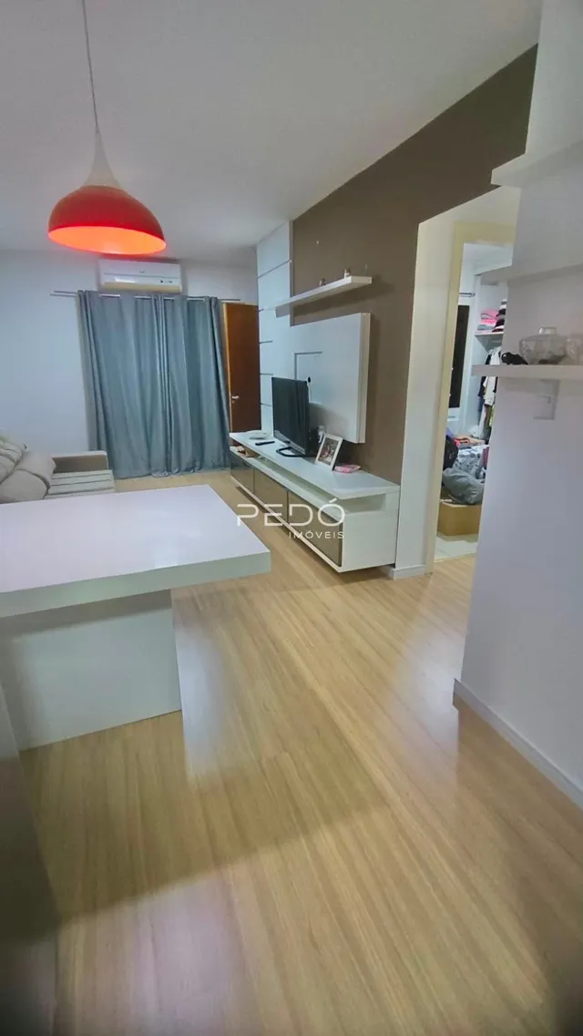 Sala de estar com piso de madeira clara e paredes brancas.