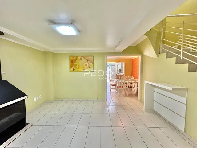 Sala de estar com paredes verdes e piso de cerâmica branca.