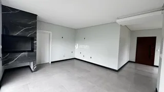 Uma sala de estar ampla com piso de cerâmica cinza e parede de mármore preta.