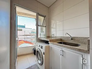 Foto de uma área de serviço com máquina de lavar roupa e vista para o exterior.