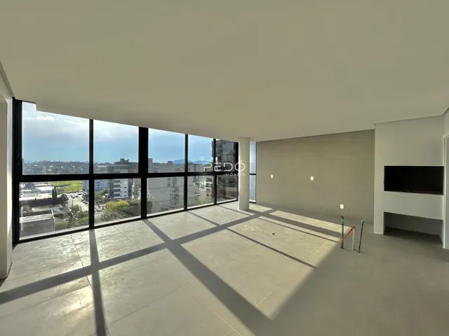 Sala ampla com grandes janelas oferecendo uma vista panorâmica.
