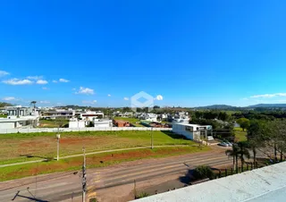 Vista aérea de uma área residencial com campos e casas no Brasil.