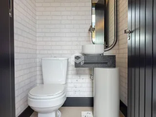 Foto de um banheiro com revestimento de azulejo branco.