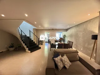 Sala de estar ampla com sofá e escadaria visível.