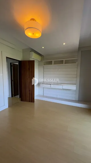 Interior de um ambiente com piso de madeira clara e paredes brancas.