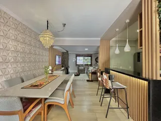 Interior de uma sala de jantar com mesa e decoração moderna em Lajeado.