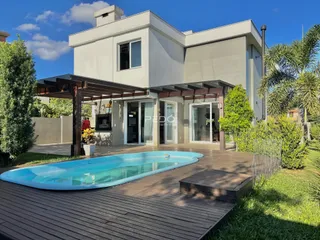 Fachada de uma casa em Lajeado, Brasil, com piscina e deck.