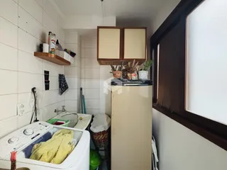 Interior de um ambiente com azulejos brancos e pia.