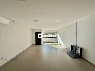 Corredor longo e claro com piso de cerâmica e parede branca.