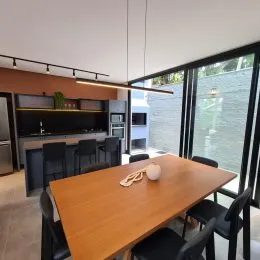 Foto de uma mesa de jantar de madeira com cadeiras em um ambiente interno.