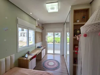 Quarto interno com paredes verdes e móveis de madeira clara.