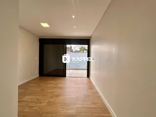 Hall de corredor com piso de madeira e acesso a uma área externa.