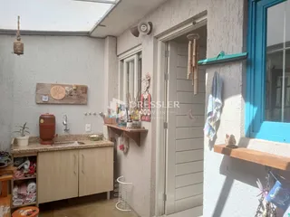 Interior de uma sala com janela e porta em uma residência.