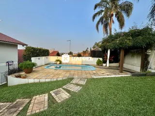Foto da área externa com piscina e jardim de uma propriedade em Lajeado.